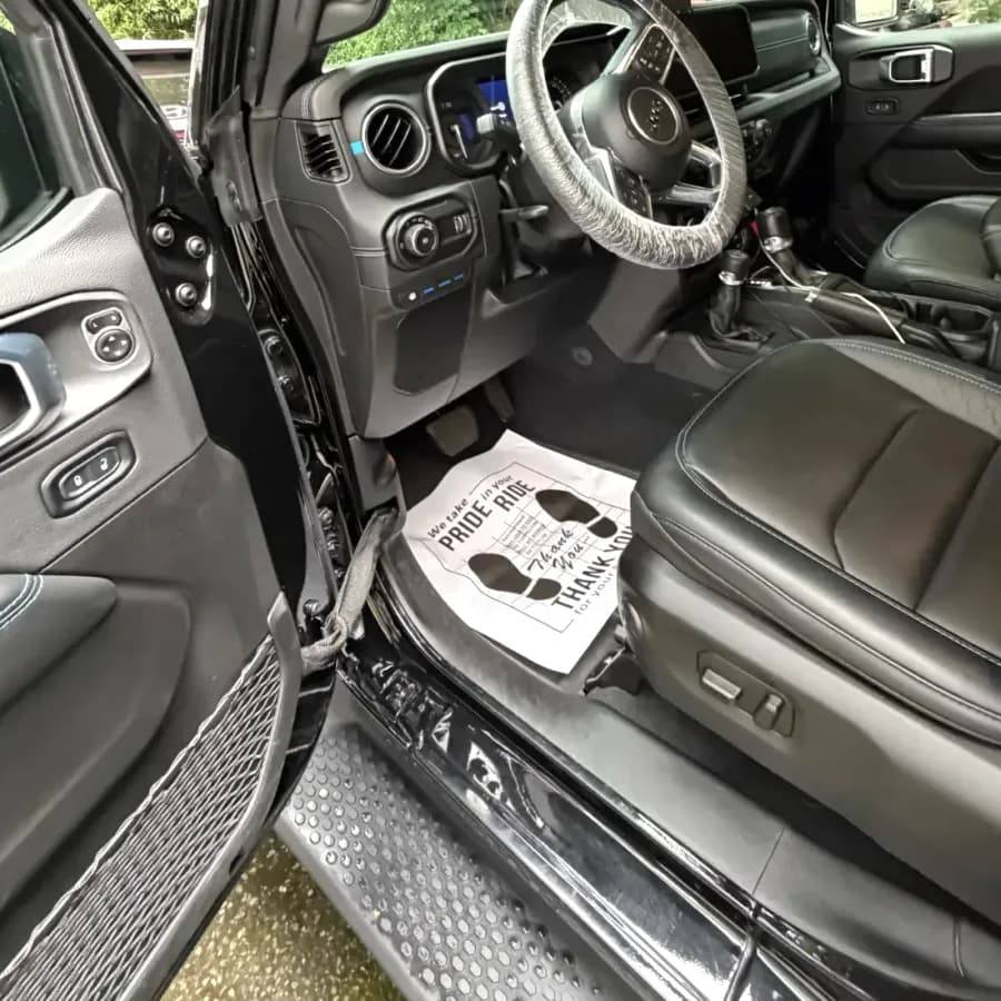 Interior of a black SUV after a detail: clean leather seat, dashboard and door panel